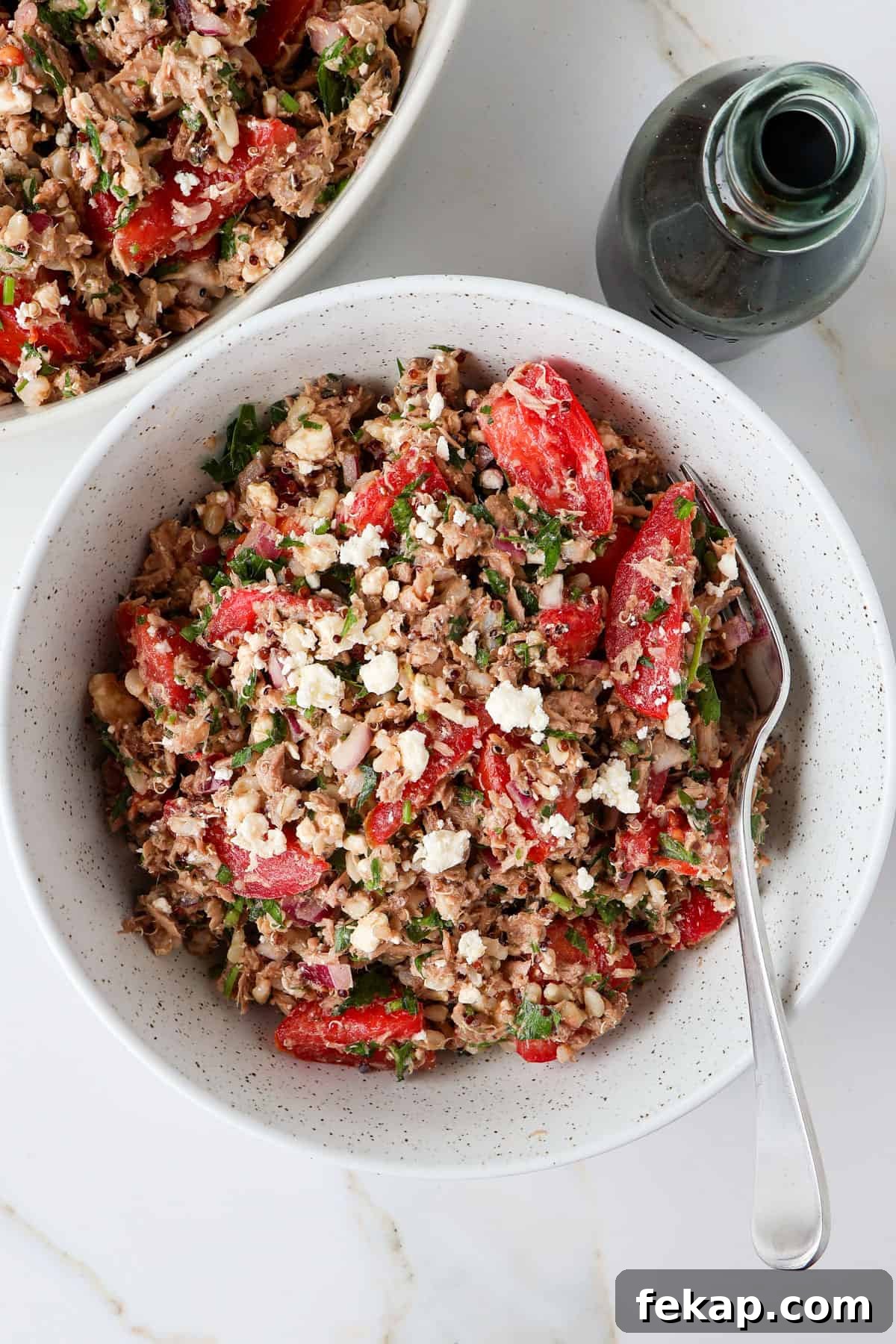 Mediterranean Tuna and Tomato Salad Recipe 3 Tuna tomato salad served in a bowl with a fork.