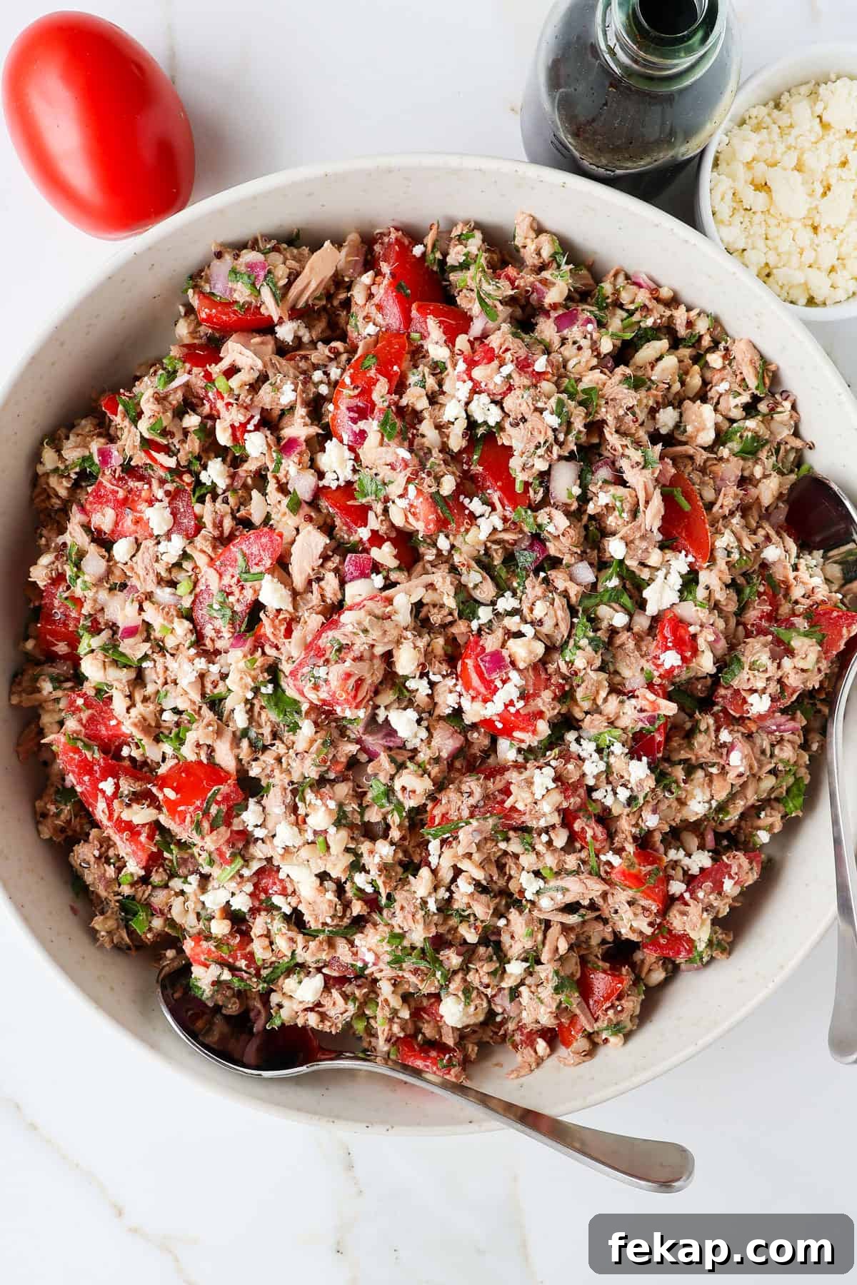 Mediterranean Tuna and Tomato Salad Recipe 6 Tuna tomato salad in a bowl with two spoons.
