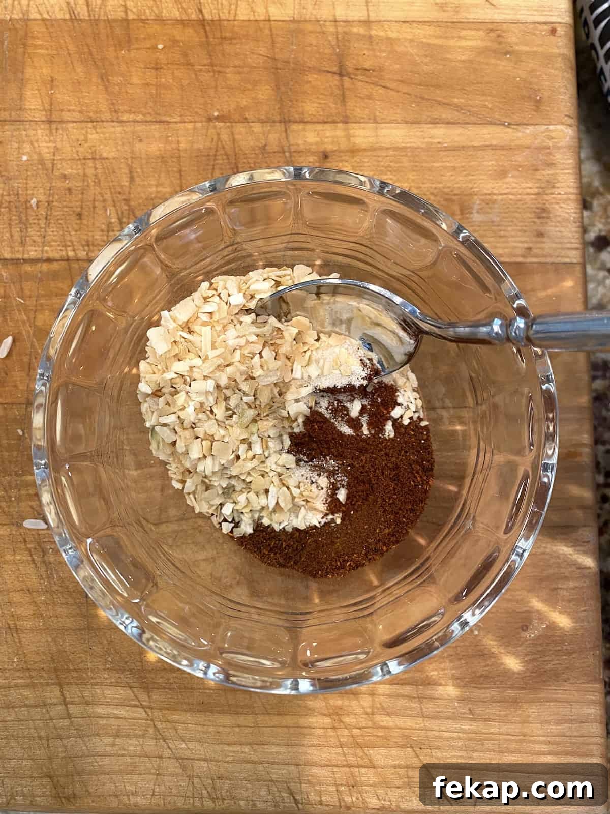 Restaurant-Style Mexican Fried Rice Recipe 6 Spices and dried onion in a small bowl with a spoon.