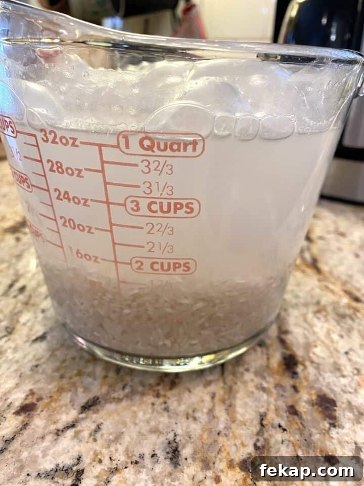 Restaurant-Style Mexican Fried Rice Recipe 7 Rice and water in a glass measuring cup.