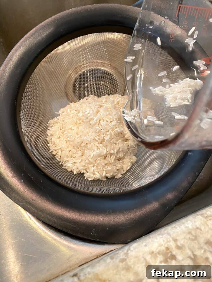 Restaurant-Style Mexican Fried Rice Recipe 8 Rice in a strainer over the kitchen sink.