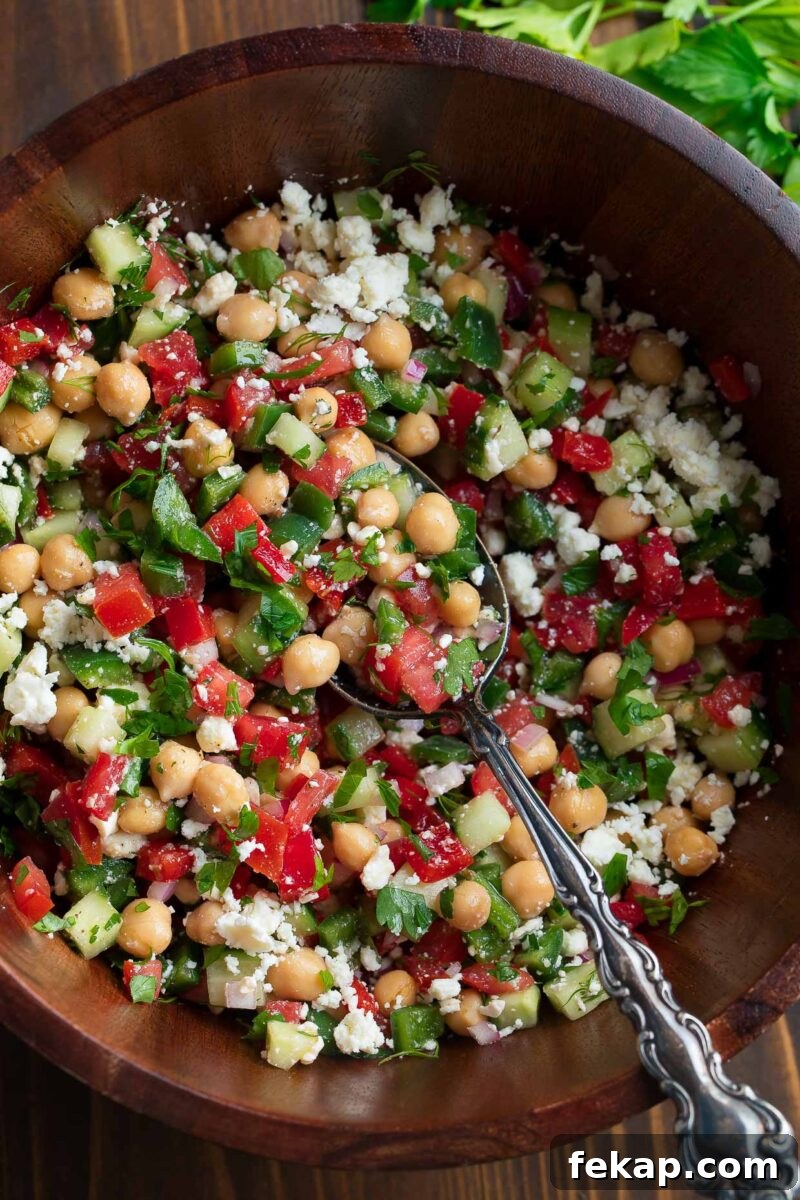Mediterranean Chickpea and Feta Salad with Lemon Vinaigrette 6 Chickpea Salad with Chopped Vegetables, Crumbled Feta, and Fresh Herbs in Bowl with Dressing