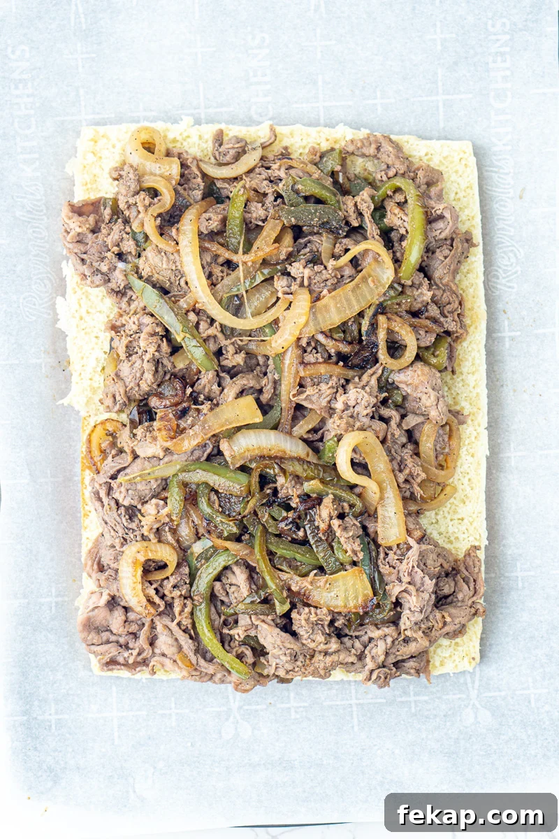 Philly Cheesesteak Sliders on Hawaiian Rolls Game Day Recipe 6 Steak and veggie mixture is spread on top of the bottom part of Hawaiian rolls.