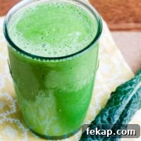 a glowing green smoothie and a piece of kale