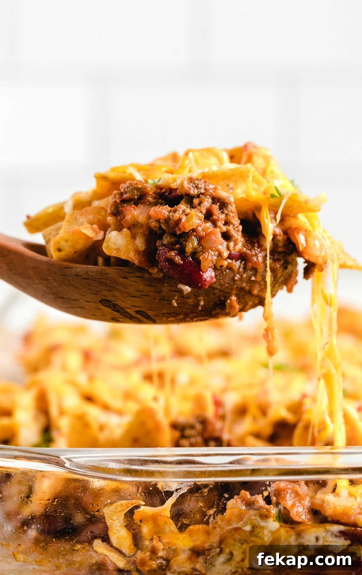 Frito Pie Casserole Recipe: Baked Chili and Cheese 9 close up shot of a spoon with a piece of Frito Pie