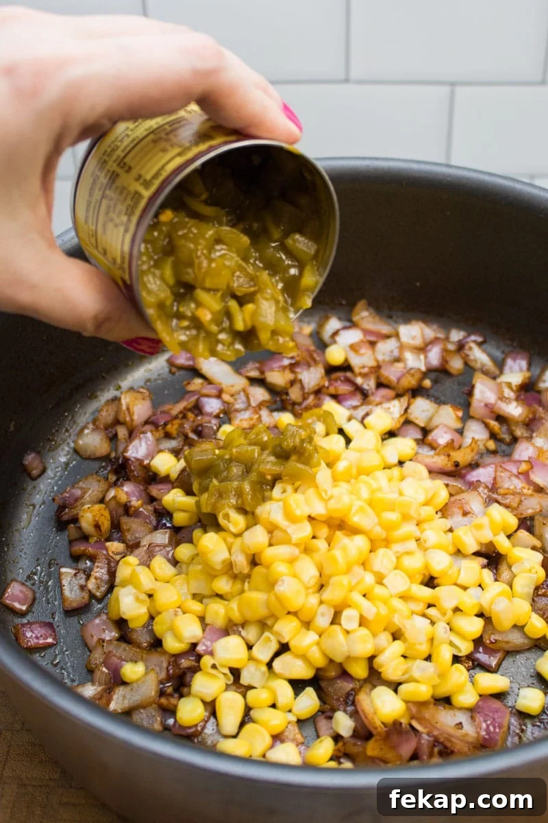 Adding green chiles to a sauté pan.