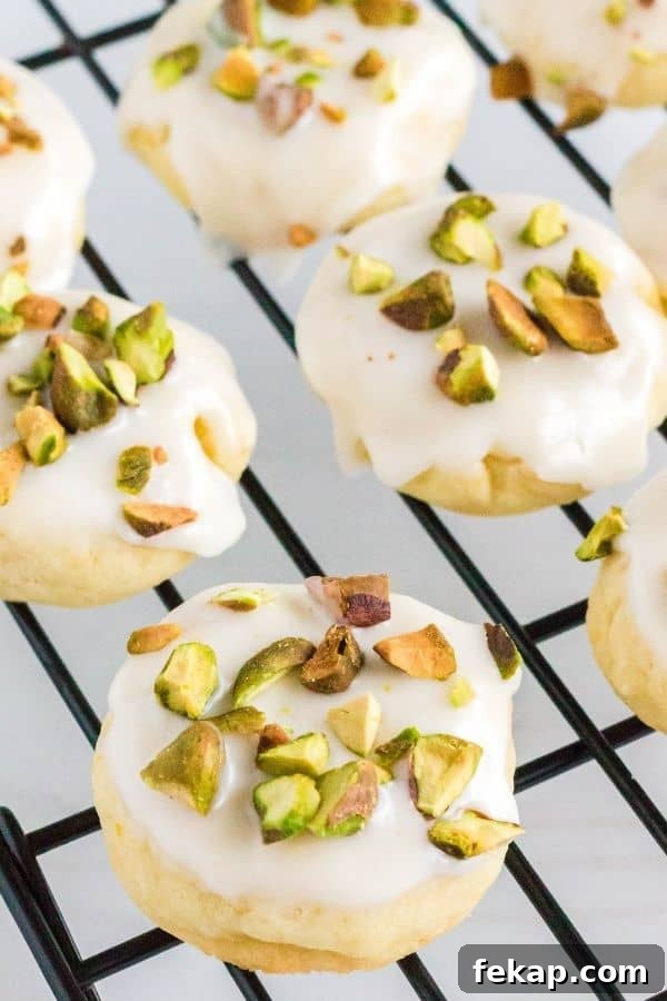 freshly iced lemon pistachio cookies on a cooling rack