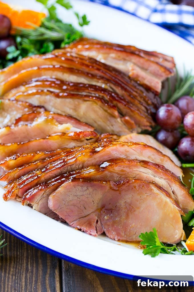 Sliced coca cola ham A platter of sliced coca cola ham with herbs.