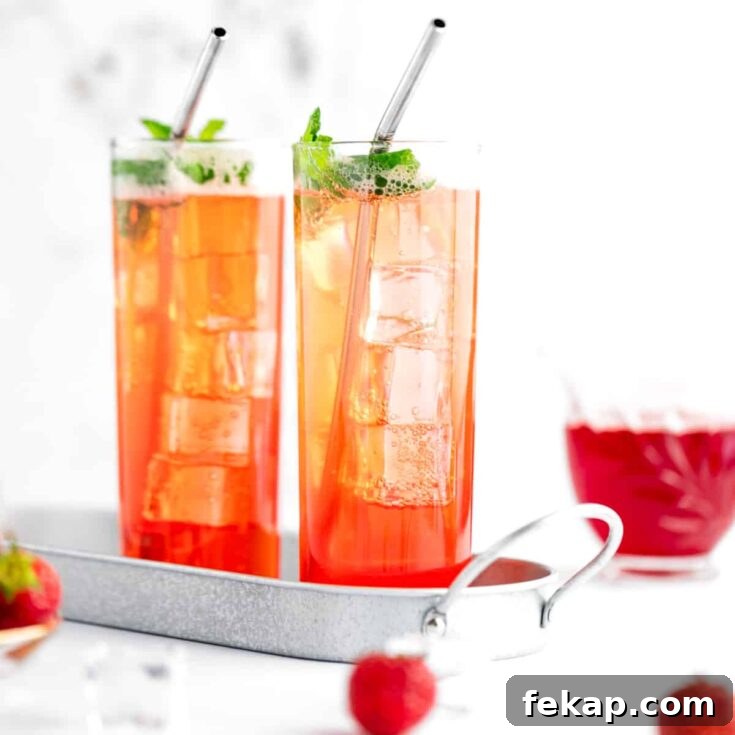 A non alcoholic strawberry mojito garnished with mint, served in a metal tray.
