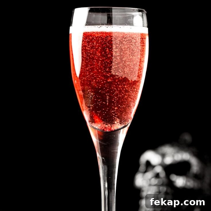 A red halloween mimosa on a black background, with a skull in the background.