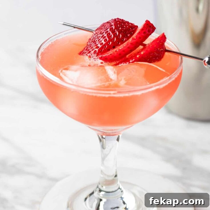 A Strawberry Daiquiri On The Rocks garnished with strawberry slices.