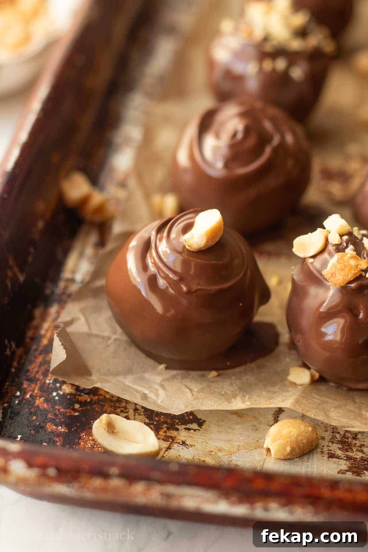 Dipped peanut butter ball on baking sheet.