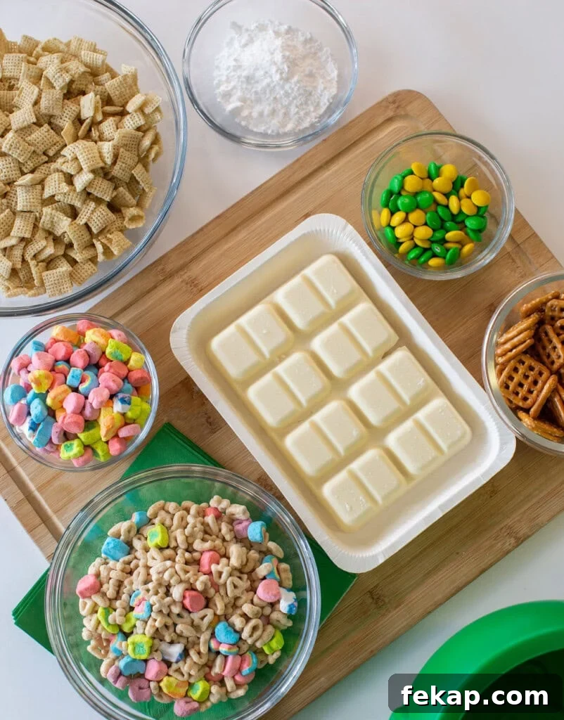 Lucky Charms Puppy Chow: Leprechaun Bait Recipe 3 Bowls of Chex cereal, Lucky Charms, pretzels, powdered sugar, and green and yellow candy with a tray of white chocolate on a wooden board, ready for a snack mix recipe.