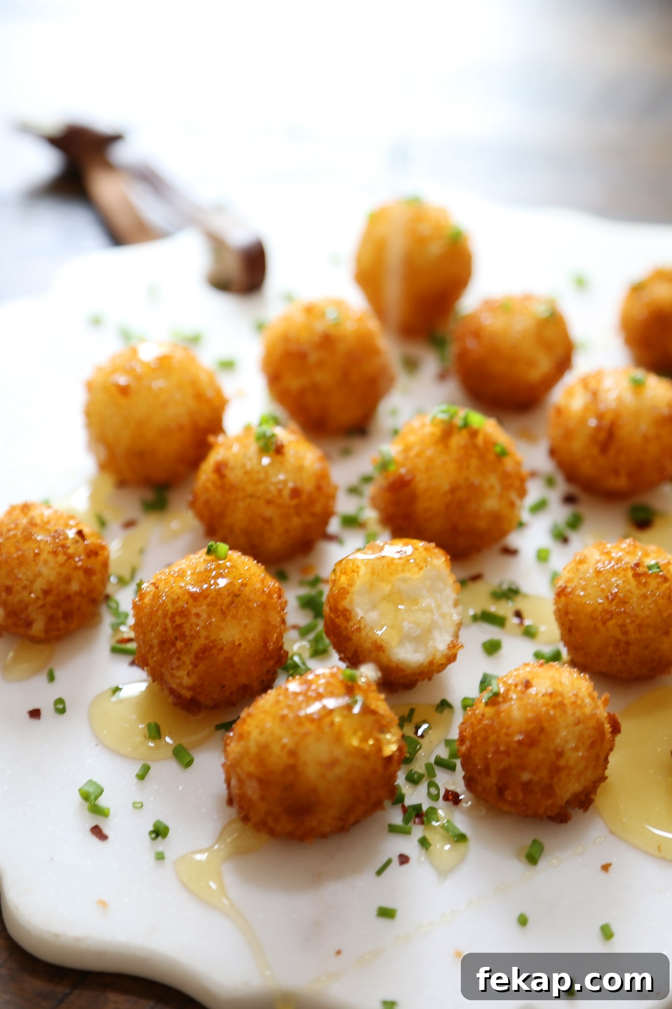 Crispy Goat Cheese Poppers with Honey Drizzle 3 Homemade crispy goat cheese poppers served as an appetizer