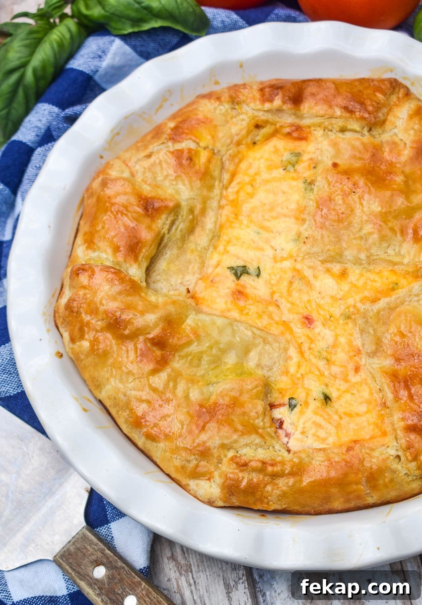 Savory Tomato Pie with Flaky Puff Pastry Crust 3 a tomato pie with puff pastry crust in a white pie dish