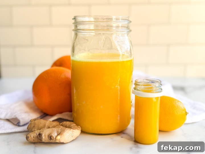DIY Ginger Immunity Shots for Cold and Flu Defense 4 Blended ginger shot mixture being strained