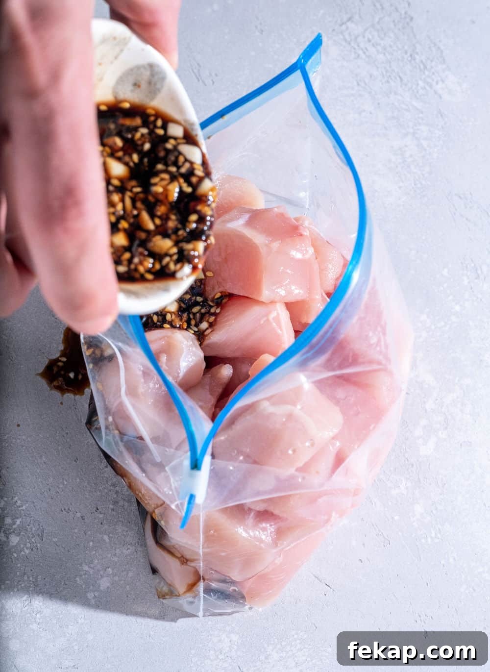 freezer meal prep with sauce and raw chicken