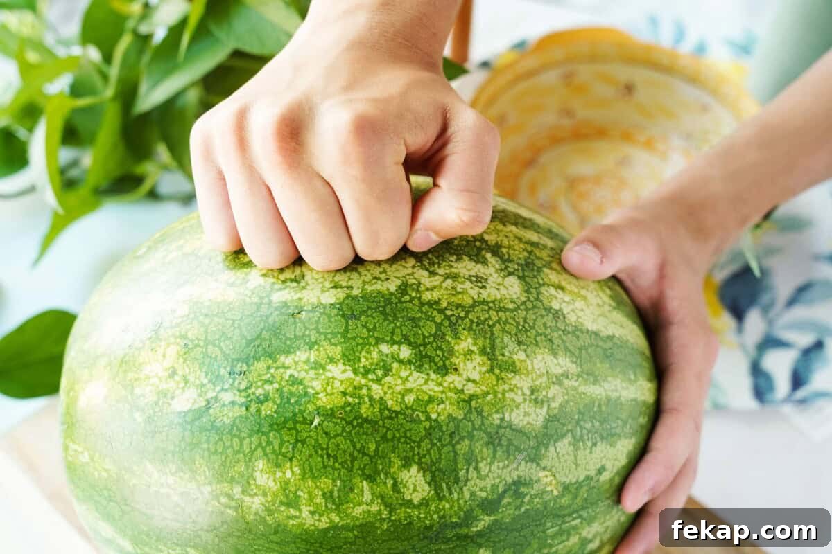 Hand knocking on watermelon