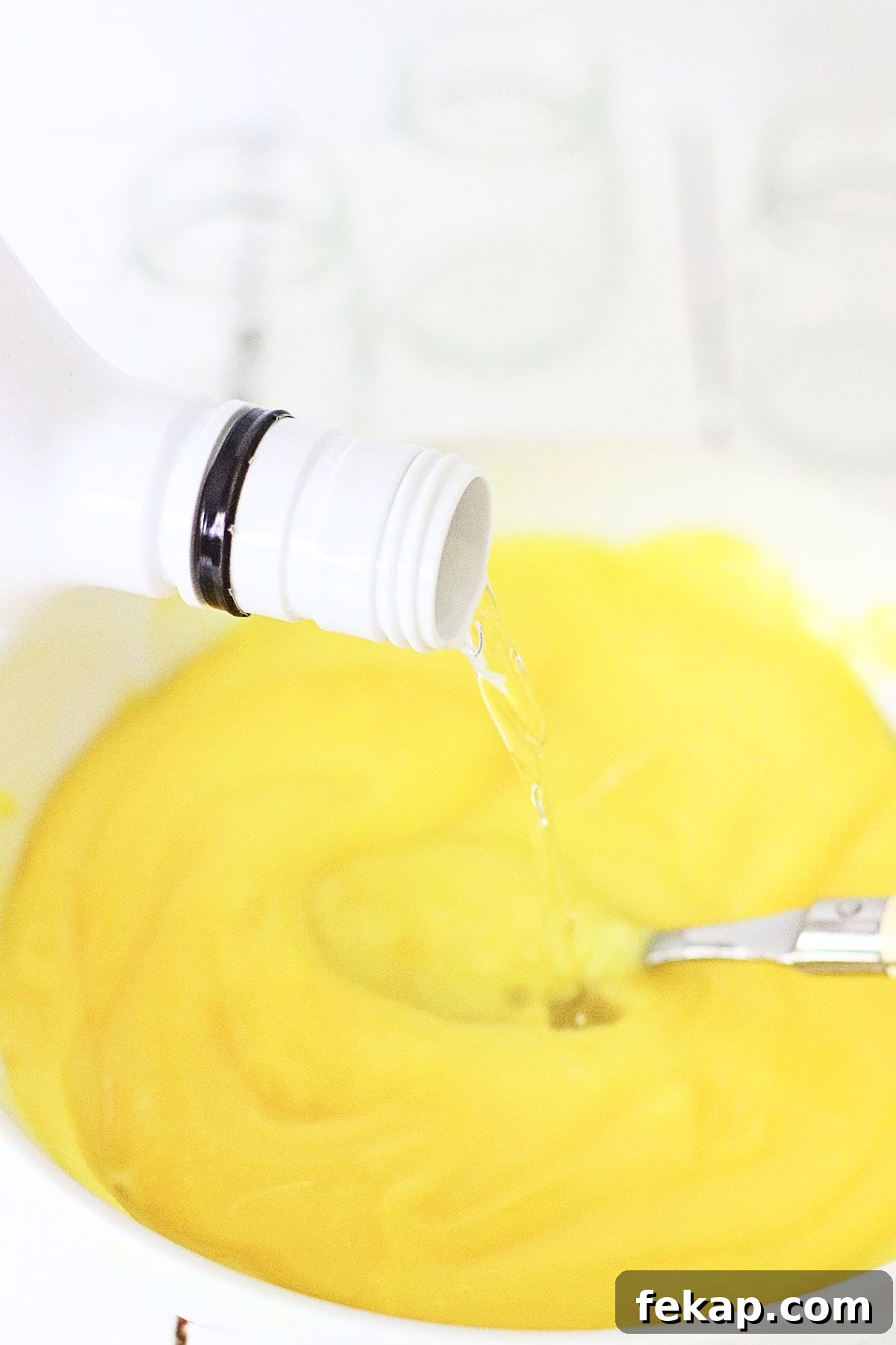 Creamy Banana Pudding Shots Recipe for Parties 4 Small white bowl with banana pudding and rum being mixed together with a spoon.