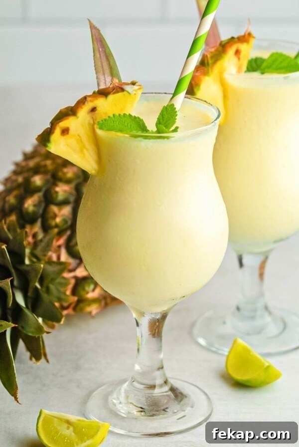 Soft yellow slushie drink of virgin pina colada in a glass.