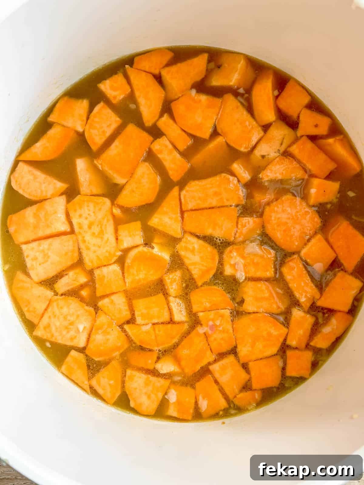 Roasted Pumpkin and Sweet Potato Soup Recipe 5 Sweet potatoes and bone broth boiling in a pan.