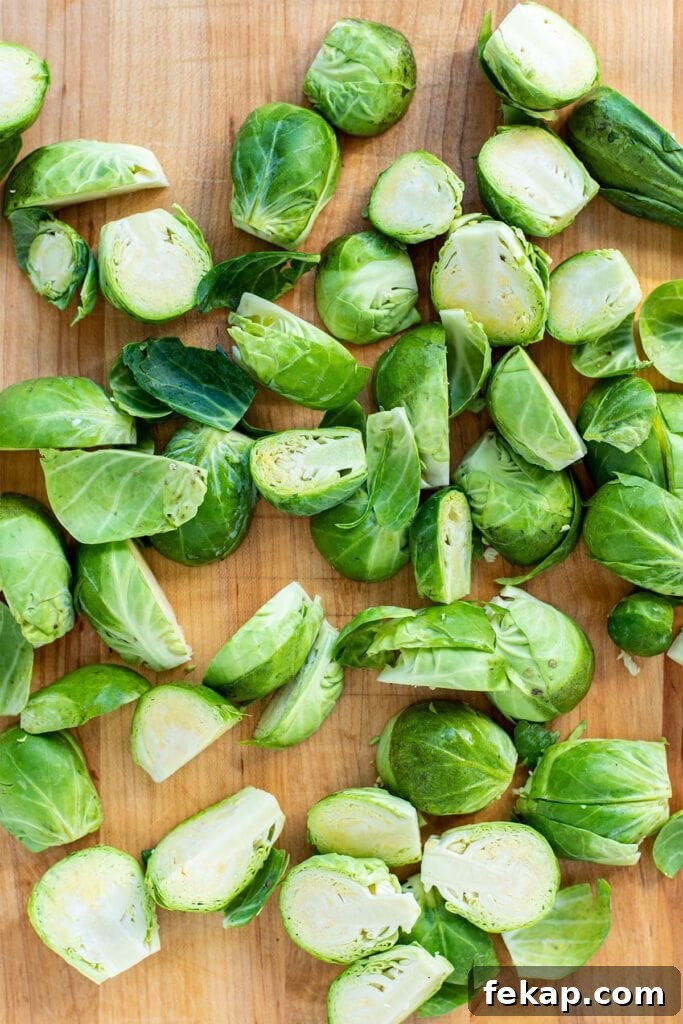 Trimmed and halved Brussels sprouts on a cutting board.