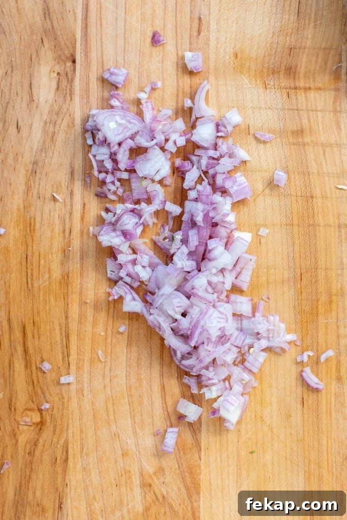 Finely diced shallots on a cutting board.