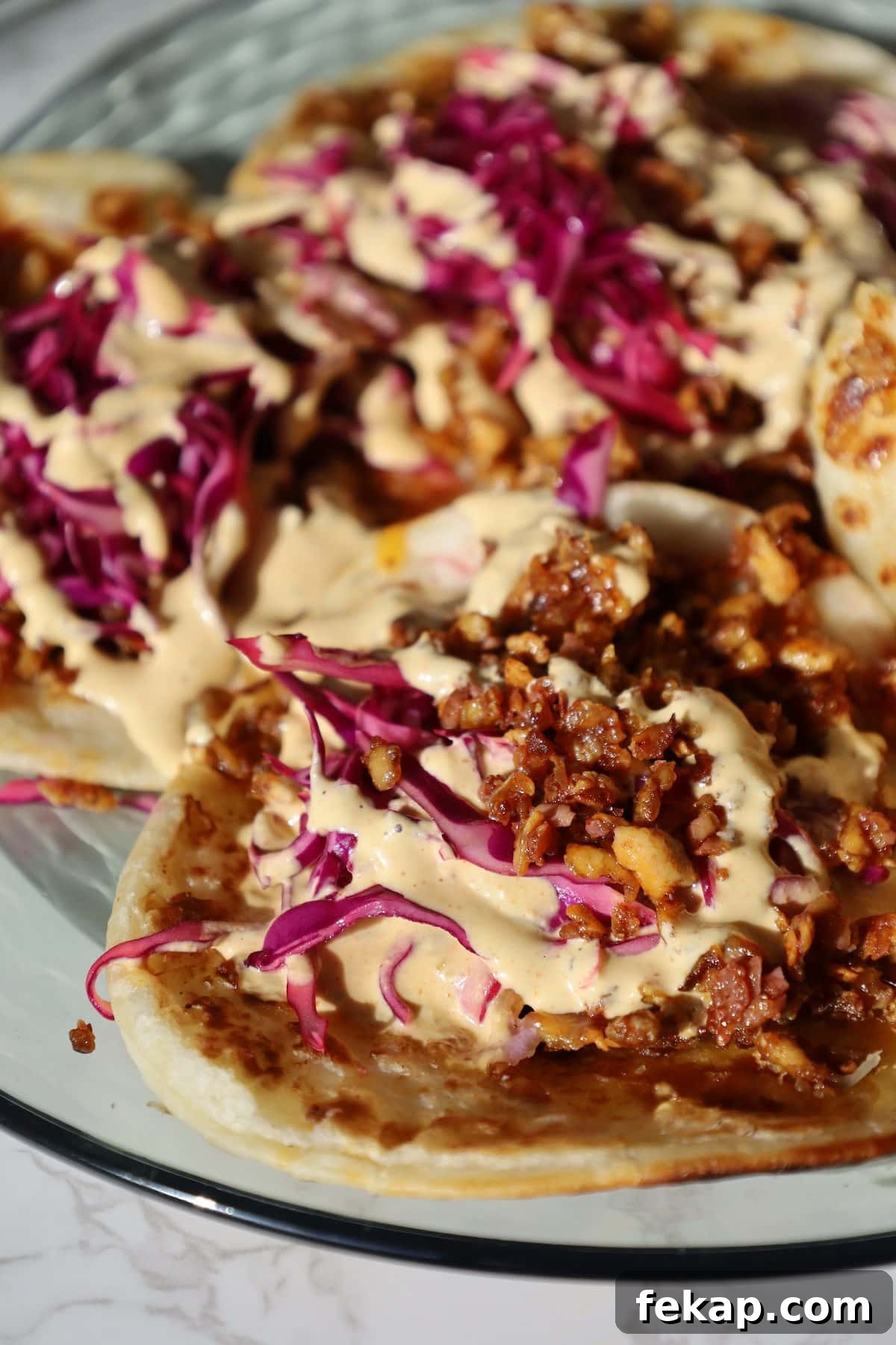 10 Tofu Recipes Meat Eaters Will Actually Love 8 Shredded tofu tacos on a plate with cabbage.