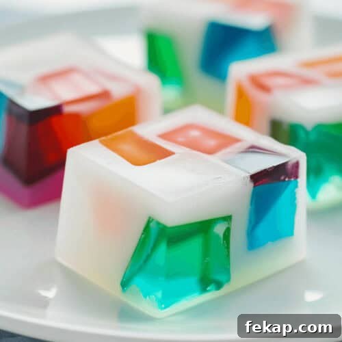 A mosaic of colorful jelly cubes on a white plate.