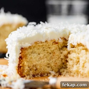 Moist Single Layer Coconut Cake Recipe 7 Sliced single layer coconut cake with black background.
