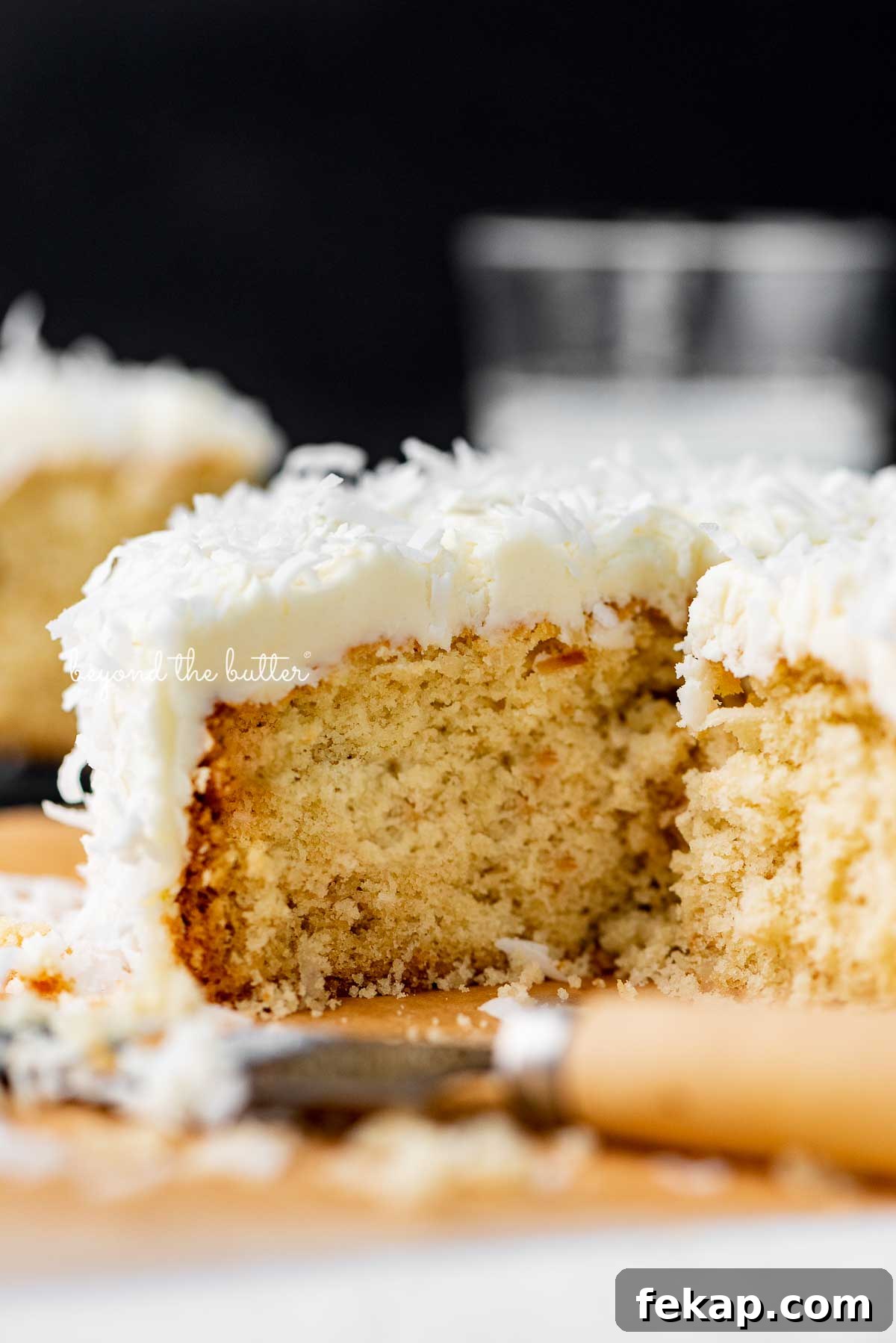 Moist Single Layer Coconut Cake Recipe 4 Sliced single layer coconut cake with black background | © Beyond the Butter®