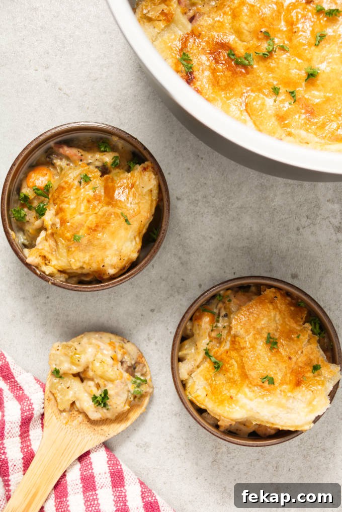 Overhead of ninja foodi turkey pot pie dished into bowls with wooden spoon