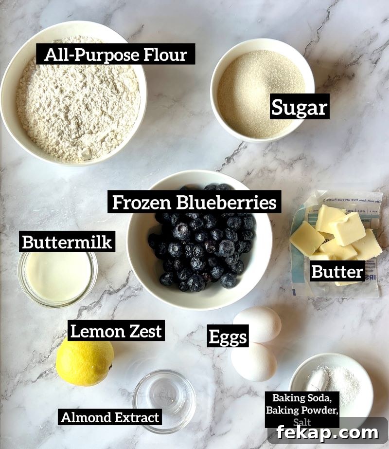Blueberry Buckle Recipe with Fresh or Frozen Berries 2 Ingredients for blueberry buckle set out. Flour, baking soda, baking powder, lemon zest, sugar, butter, eggs, almond extract, buttermilk, frozen blueberries.