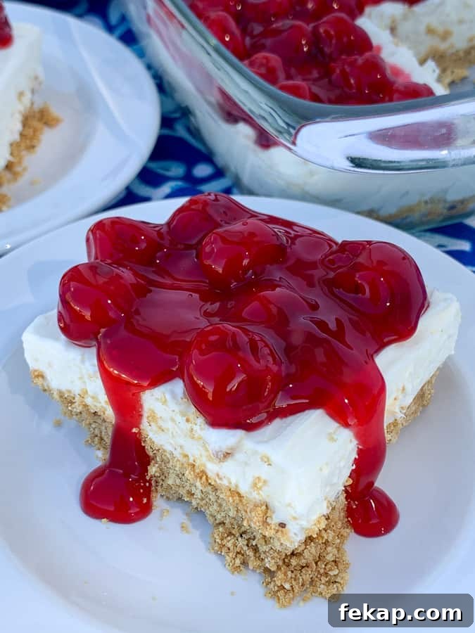 No-Bake Cherry Delight Recipe 2 Pan of cherry delight dessert next to piece on a white plate