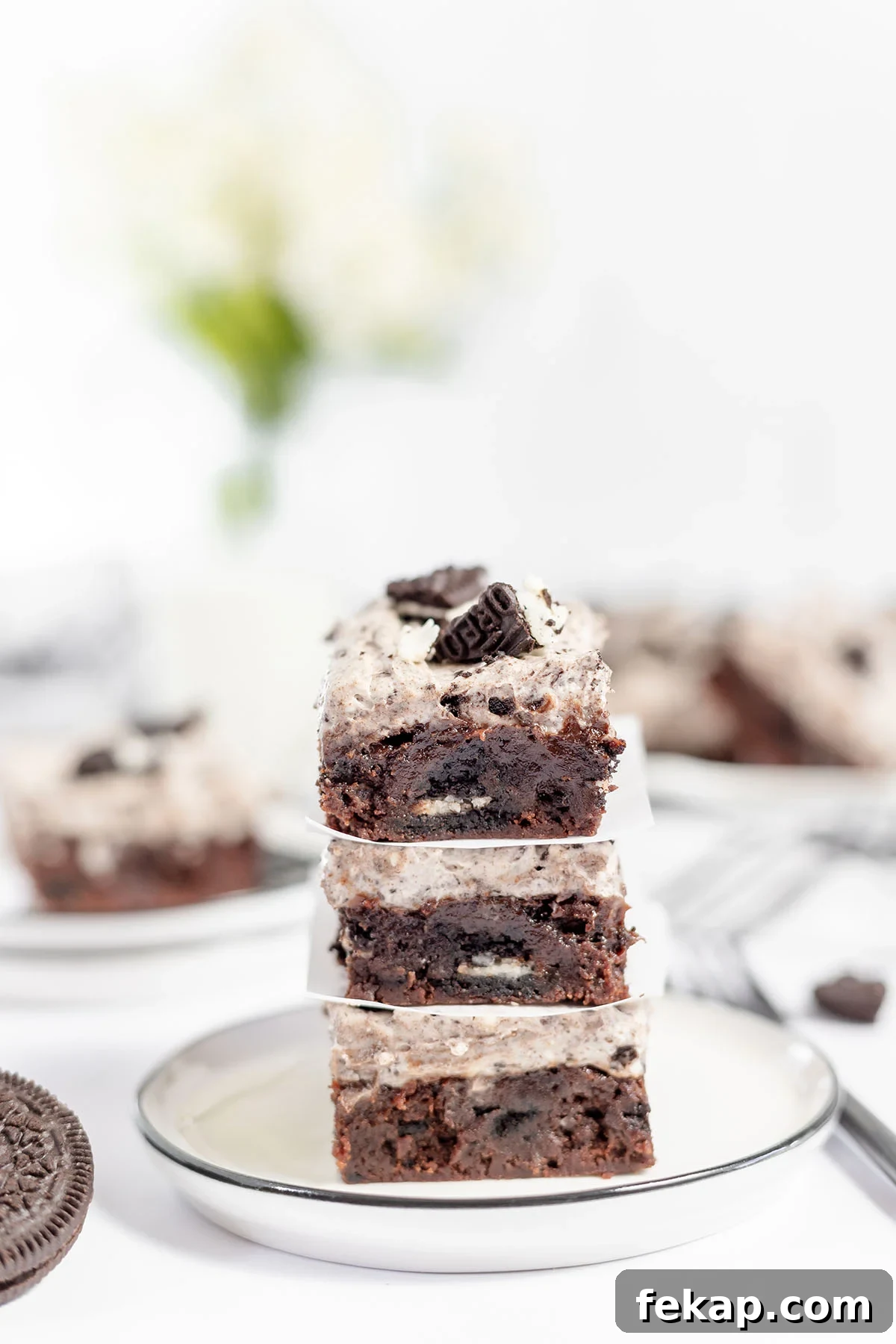 Cookies and cream brownies stacked on a plate.