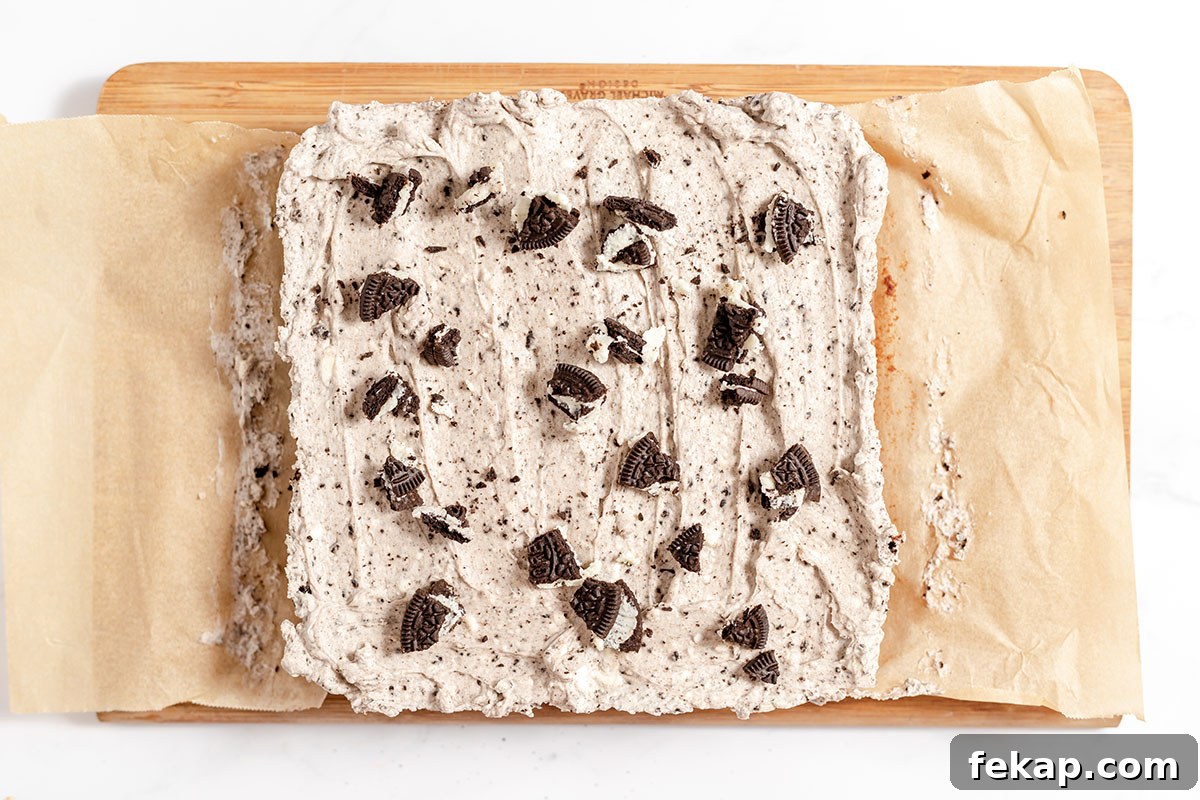 Cookies and cream brownies topped with cream cheese Oreo frosting and chopped Oreos.