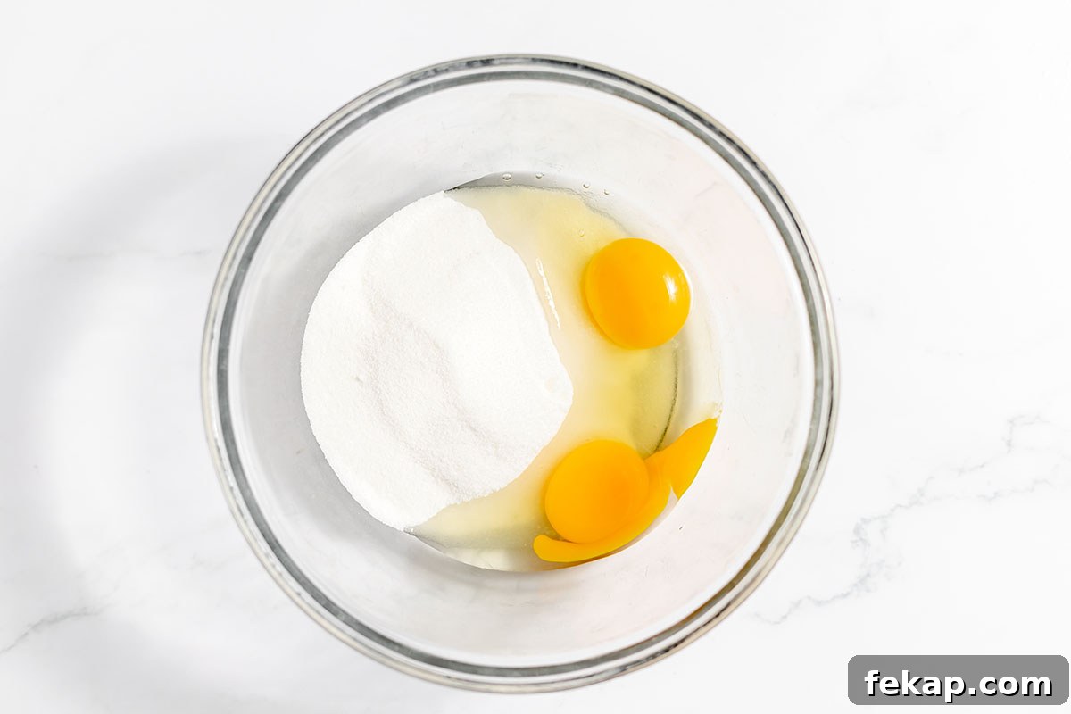 Eggs and sugar in a mixing bowl.