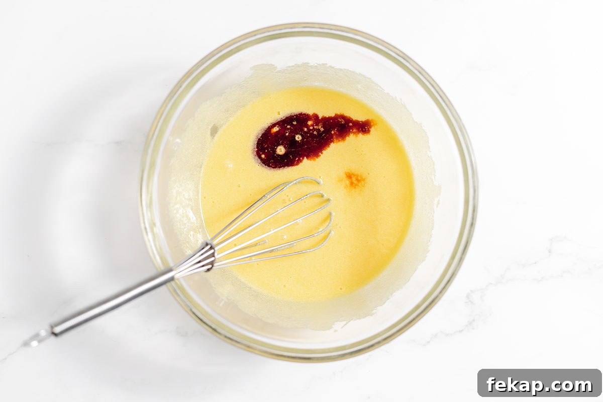 Melted butter and vanilla are added to the sugar mixture in the mixing bowl.