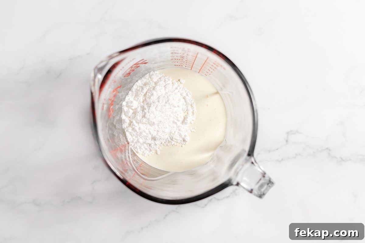 Heavy whipping cream and powdered sugar in a mixing bowl.