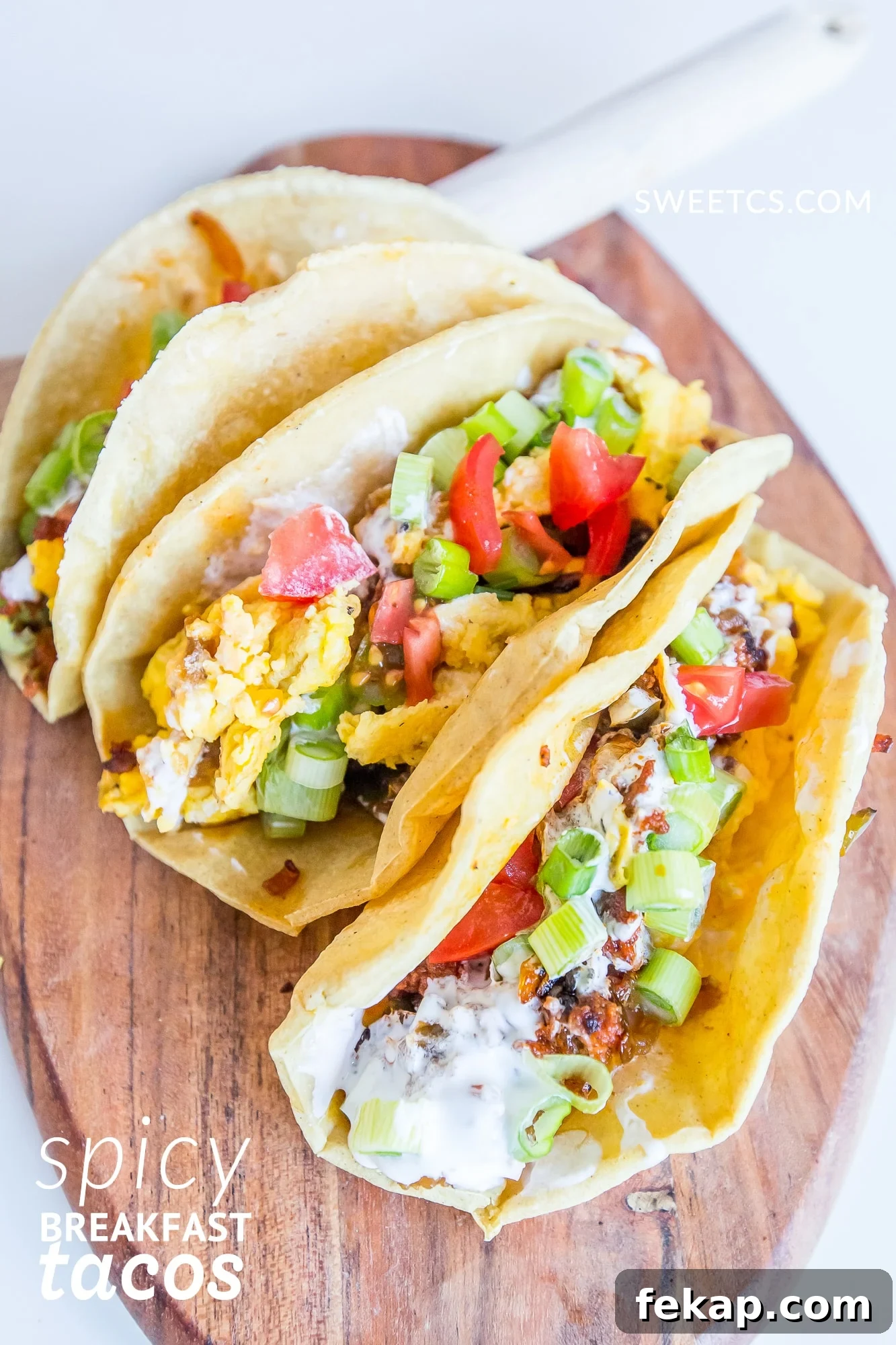 Chorizo Breakfast Tacos with Spicy Eggs 3 Spicy breakfast tacos presented on a wooden cutting board