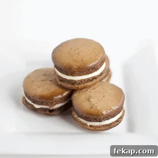 Four Root Beer macarons on a white plate.