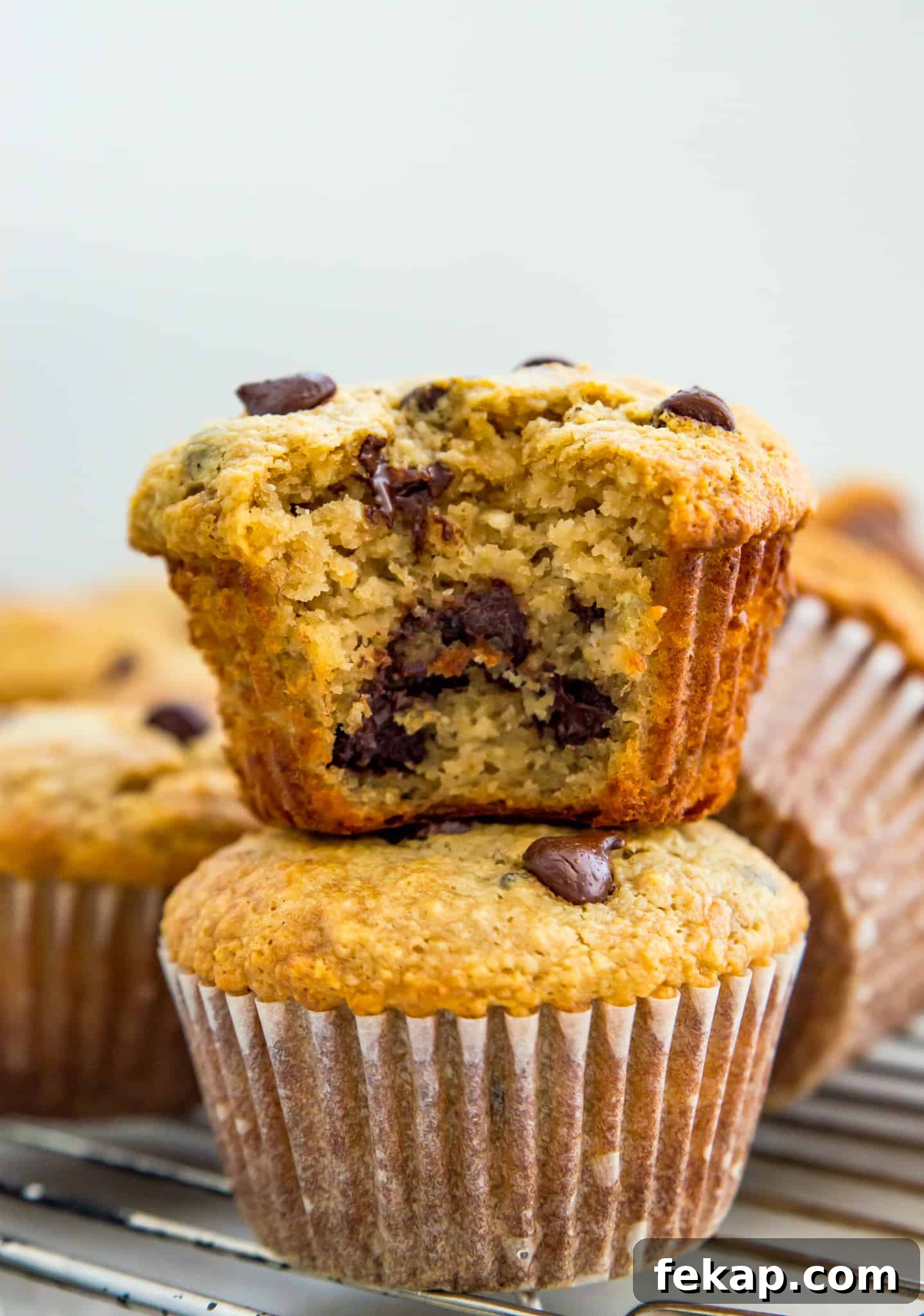 Banana Protein Muffins Recipe Two banana protein muffins stacked on top of each other with a bite out of the top one.
