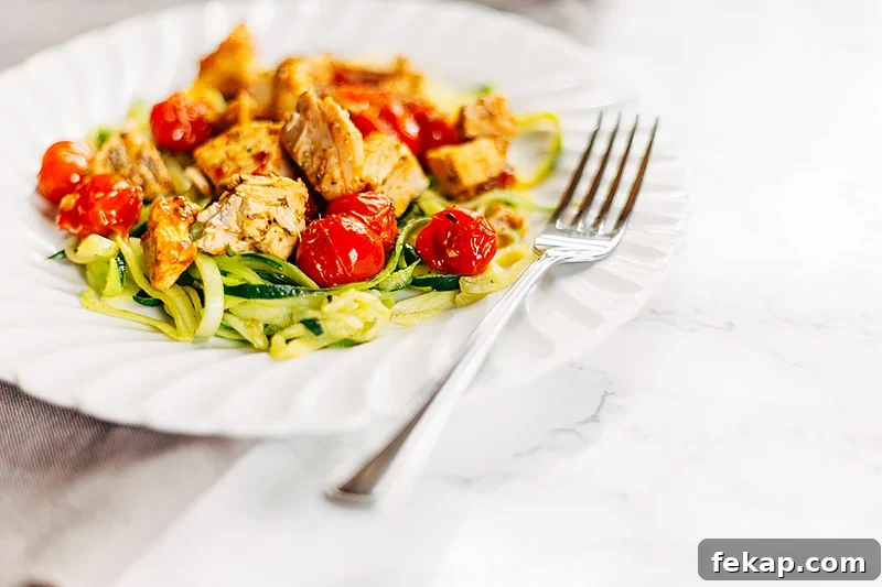 low carb Tomato Chicken Pasta with zucchini noodles on a plate with a fork