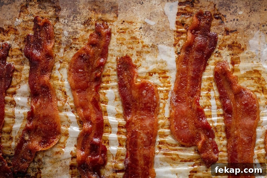 Crispy Oven-Baked Bacon: Perfectly Roasted Every Time 8 Cooked crisp bacon on a parchment paper lined baking sheet pan.
