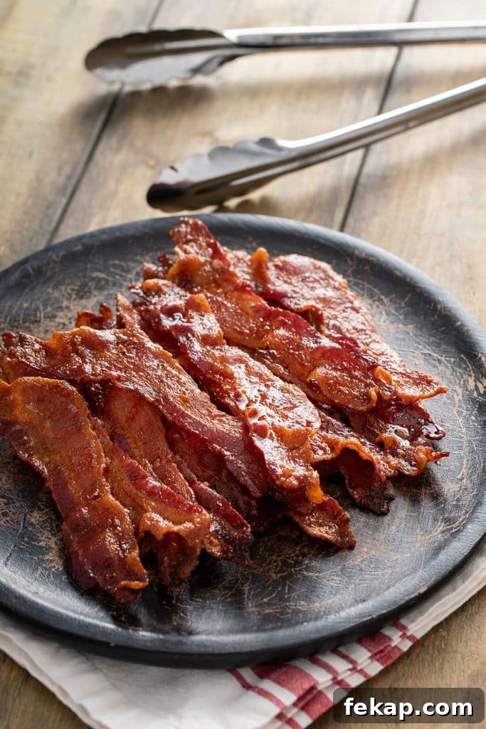 Crispy Oven-Baked Bacon: Perfectly Roasted Every Time 9 Perfectly baked bacon on a black plate.