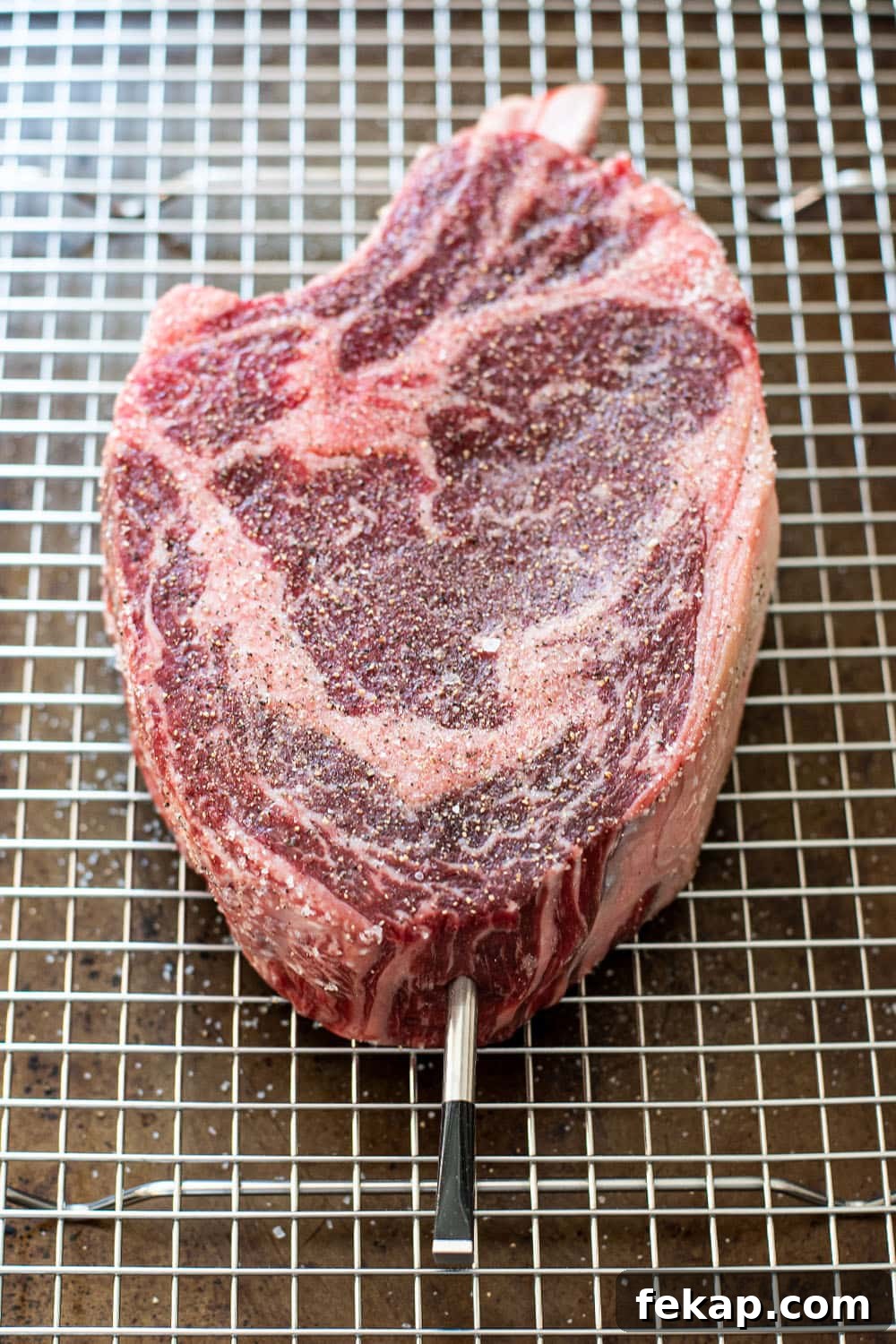 Reverse Sear Steak: Perfect Crust and Juicy Center 4 Uncooked seasoned cowboy steak with salt and pepper.