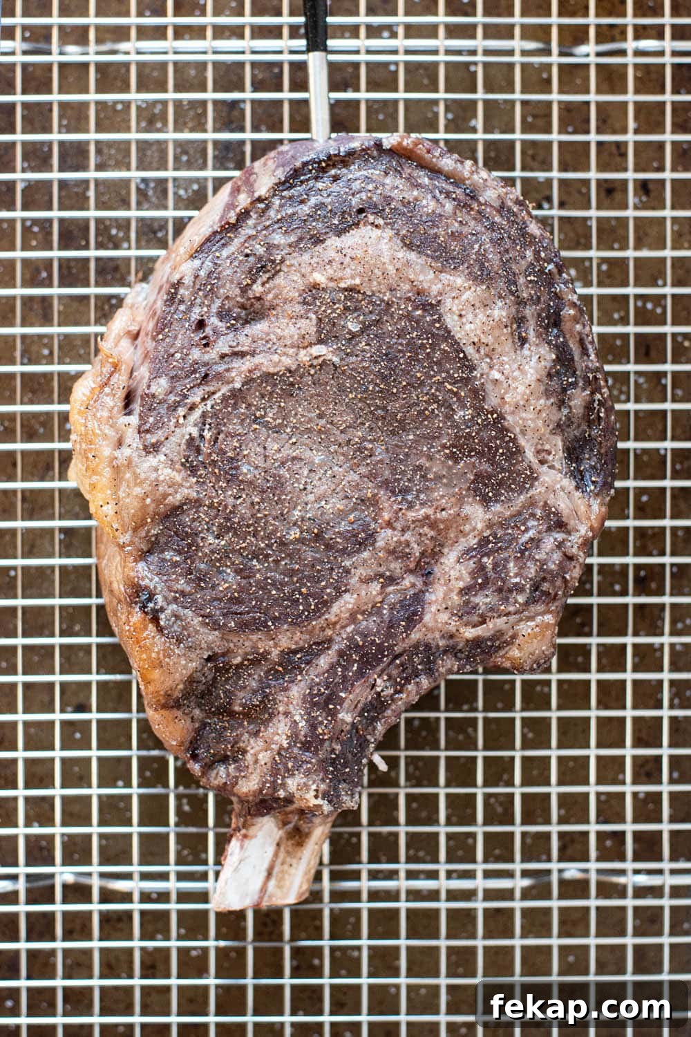 Reverse Sear Steak: Perfect Crust and Juicy Center 5 Cowboy steak after roasting in the oven on a wire lined baking sheet.