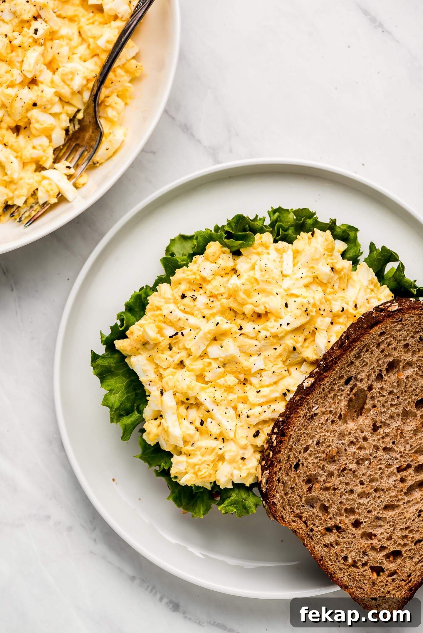 Top view of assembling an egg salad sandwich.