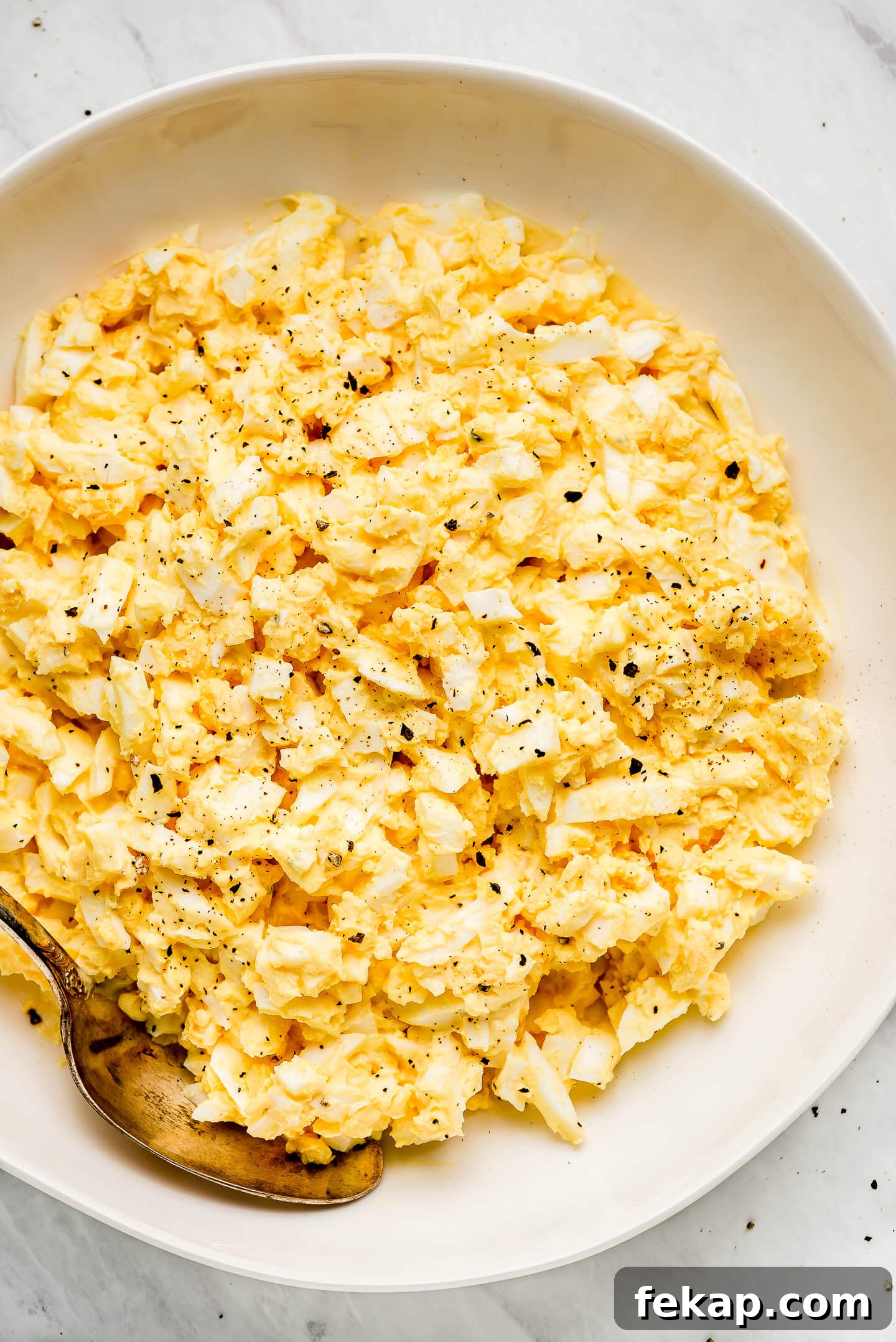 Egg Salad in a bowl sprinkled with pepper.