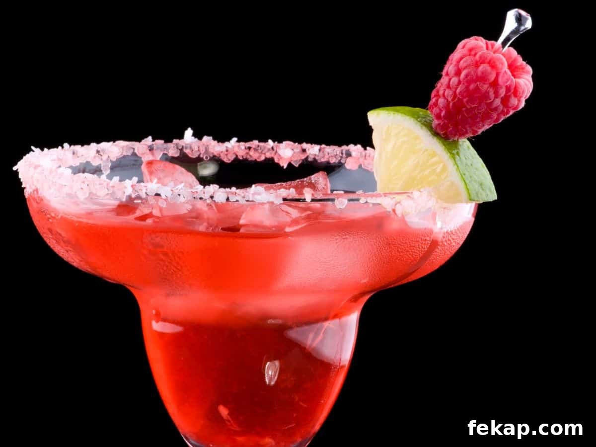Raspberry margarita with lime and salt rim.